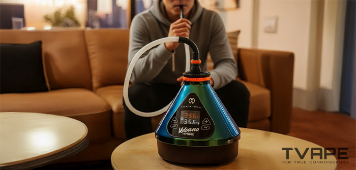 Un hombre inhala vapor del vaporizador de escritorio Volcano Hybrid (edici&oacute;n Evergreen).