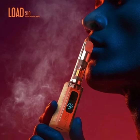Batería Lookah Load 510 en opción de color naranja, primer plano de una mujer vapenado con un cartucho conectado, con una pantalla digital azul que muestra el nivel de la batería.