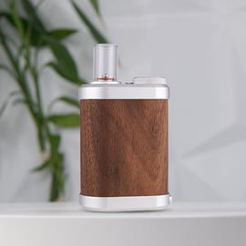 Vaporizador Tinymight 2 con cuerpo de madera elegante, detalles metálicos y boquilla de vidrio, sobre un fondo suave.