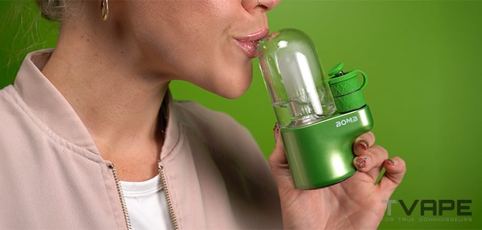 Una mujer está inhalando desde el Bomb Magloud E Rig.